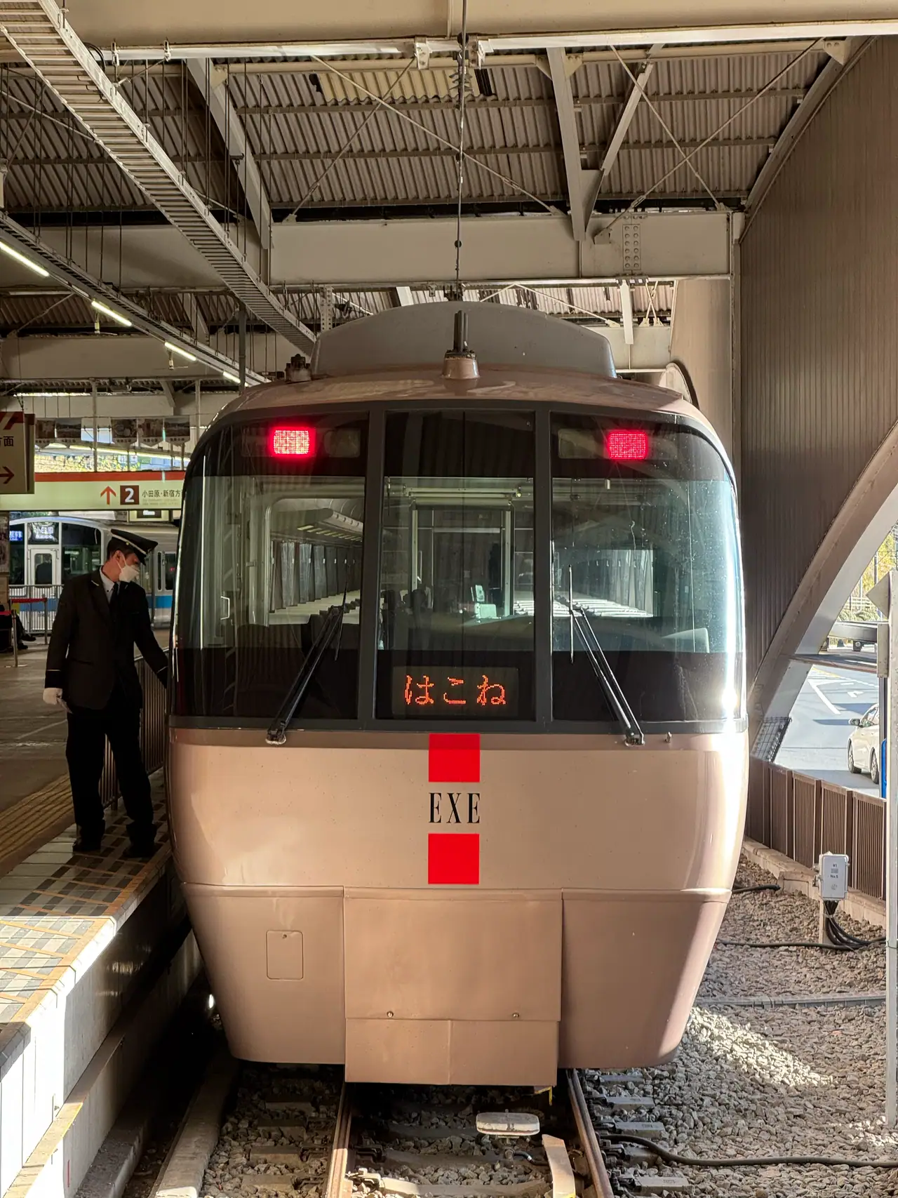 A Romancecar EXE stands head-on at the platform with its red marker lights lit.