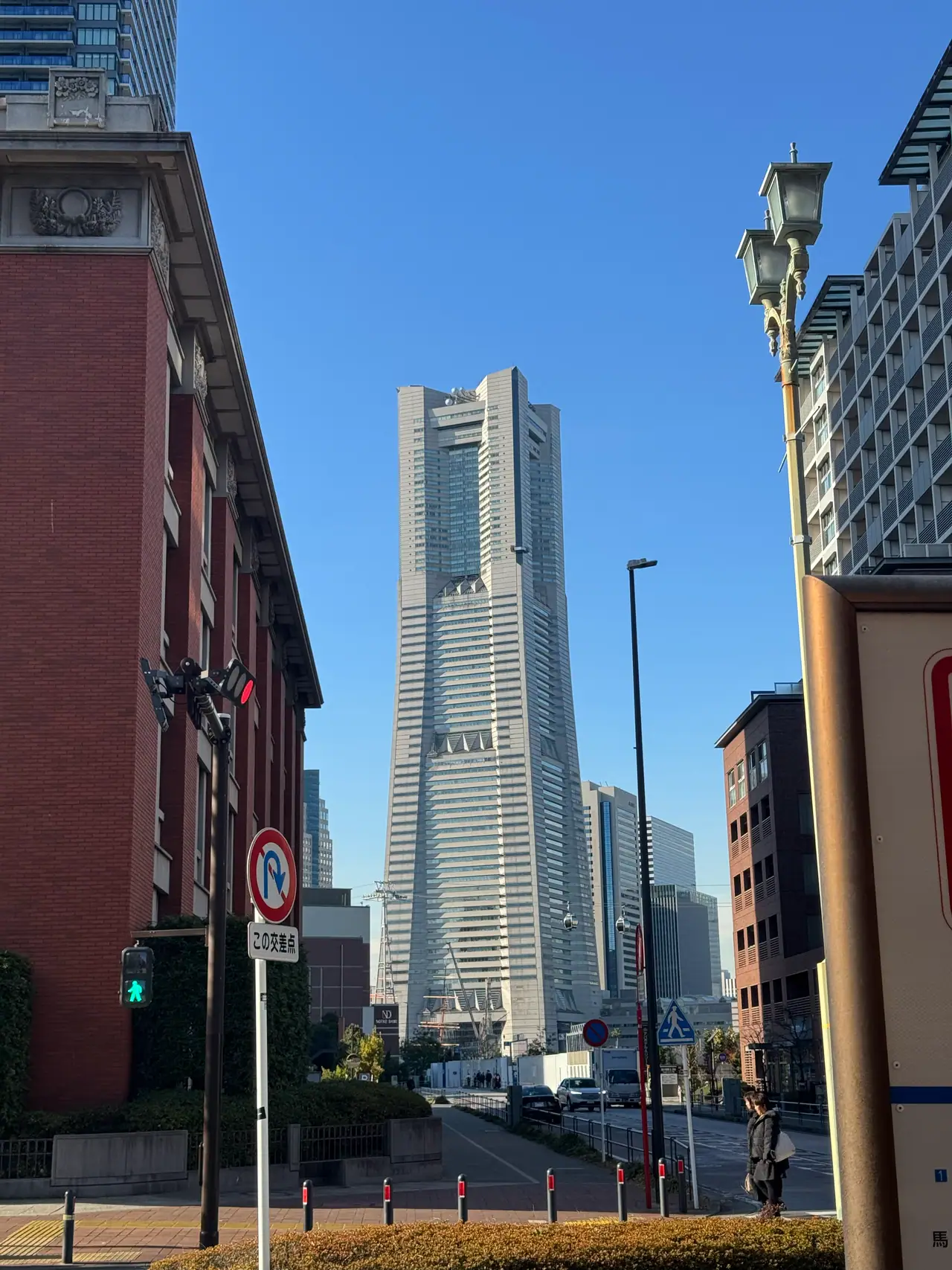The Landmark Tower stands in the gap between a red brick building and a glass block.