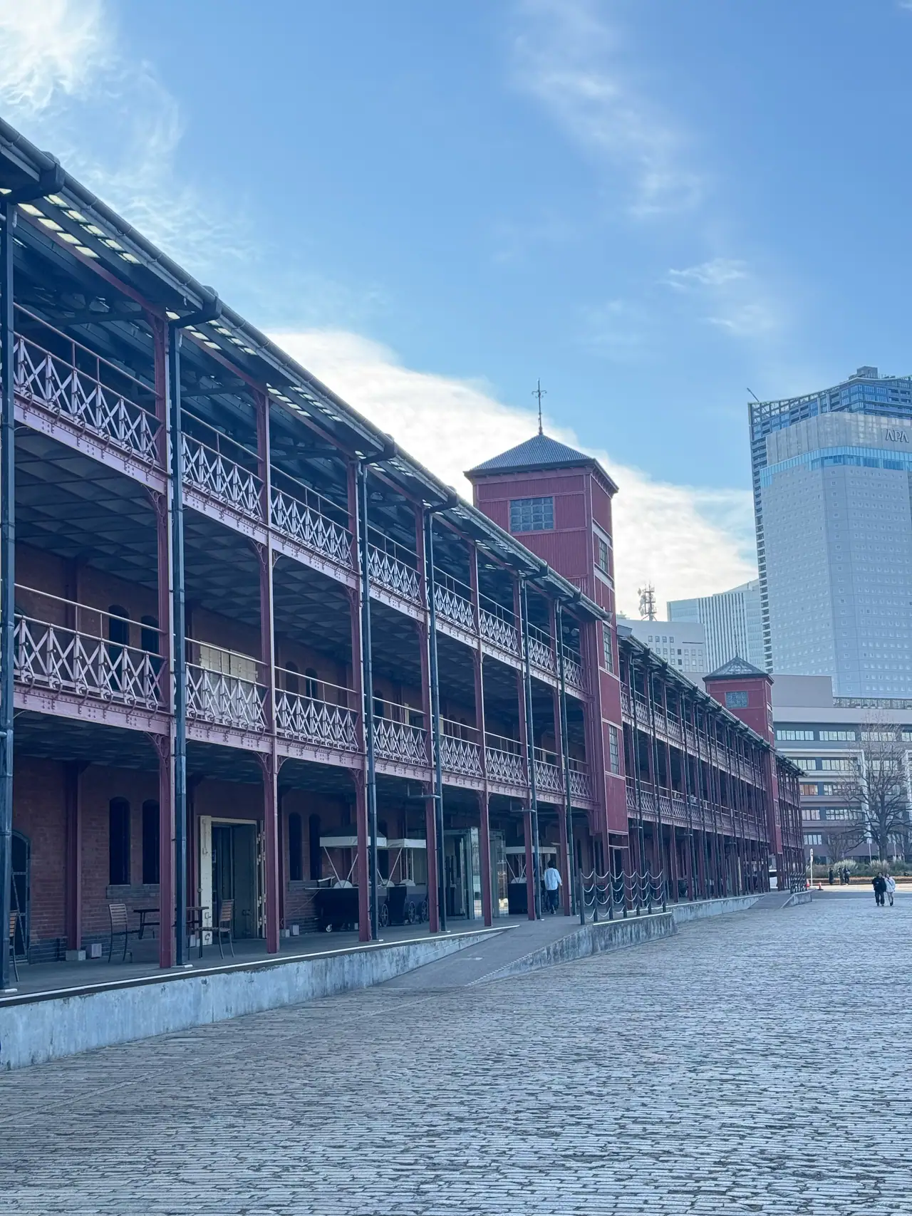 The long iron-balconied facade of the Red Brick Warehouse runs beside still water.